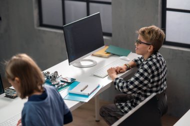 Okuldaki bir sınıfta bilgisayar kullanan öğrenciler.