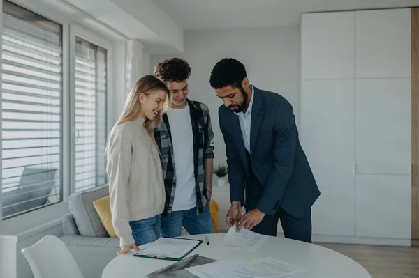 Een Jong Stel Dat Een Contract Tekent Bij Het Kopen — Stockfoto