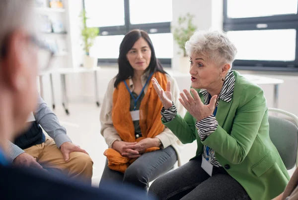 サークルに座って治療セッション中に一緒にいくつかの問題を議論する高齢者のグループ — ストック写真