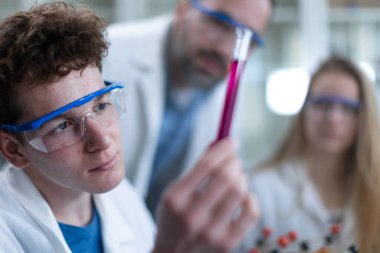 Bilim öğrencileri üniversitedeki laboratuvarda kimyasal deney yapıyorlar..