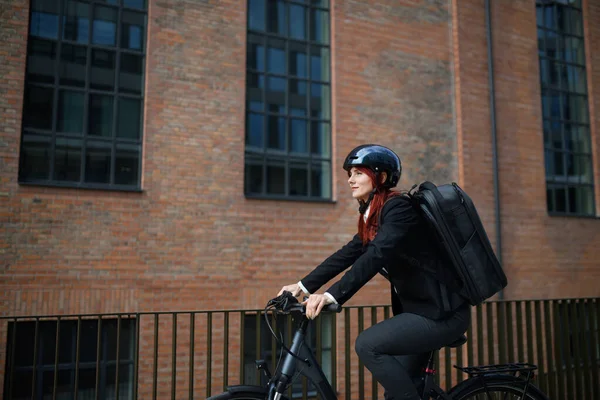 A businesswoman commuter on the way to work with bike, sustainable lifestyle concept.