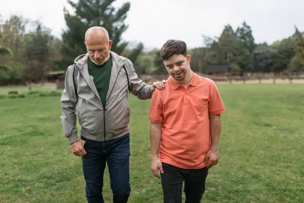 Padre Mayor Feliz Con Hijo Pequeño Con Síndrome Caminando Juntos — Foto de Stock