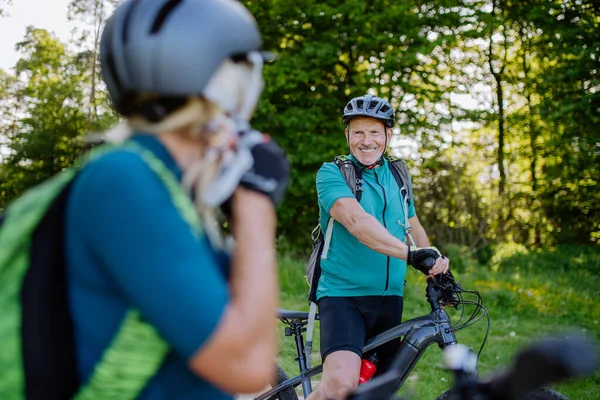 在夏季公园里 一对活跃的老夫妇骑自行车 女人戴着头盔 享受着健康的生活方式 — 图库照片