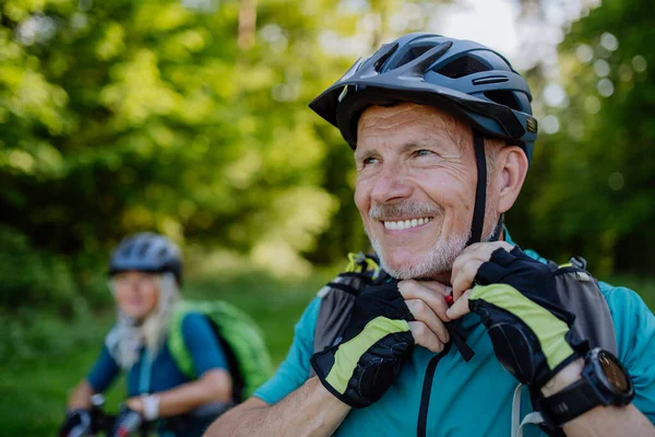 Active Senior Couple Riding Bicycles Summer Park Man Putting Helmet — Stock Photo, Image