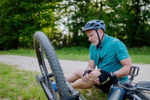 Активный Пожилой Человек Спортивной Одежде Упал Велосипеда Землю Повредил Колено — стоковое фото