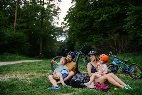 Küçük Çocukları Olan Genç Bir Aile Bisiklet Sürdükten Sonra Dinleniyor — Stok fotoğraf