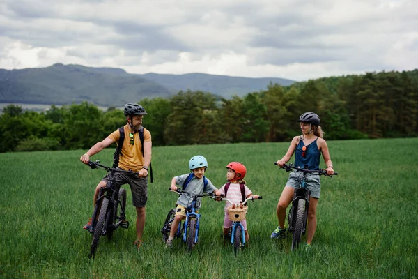 小さな子供が自転車に乗るために準備している若い家族の肖像画 自然の中で自転車と一緒に立って — ストック写真