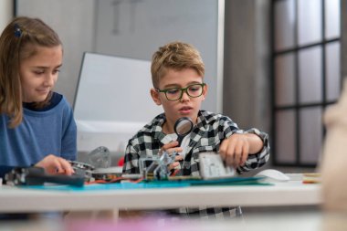 Okuldaki öğrenciler robot sınıfında elektronik bileşenler üzerinde çalışıyorlar..
