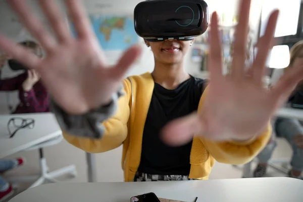 Close-up of a student wearing virtual reality goggles at school in computer science class.