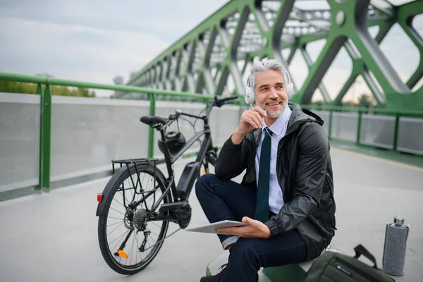 Biznesmen Rowerem Siedzącym Moście Korzystający Tabletu Słuchający Muzyki Koncepcja Dojazdów — Zdjęcie stockowe