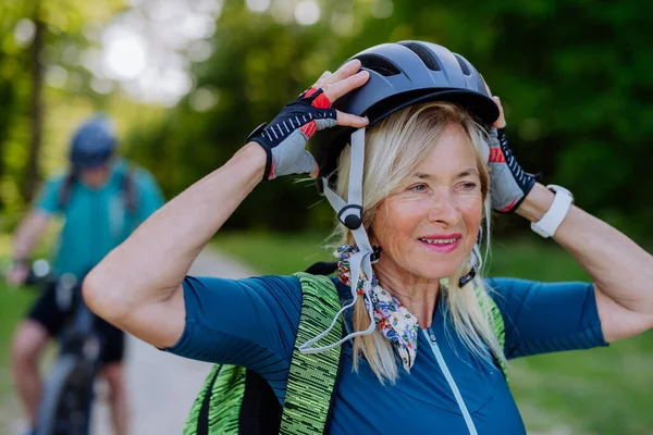 Aktywna Para Seniorów Jeździ Rowerach Letnim Parku Kobieta Zakłada Kask — Zdjęcie stockowe
