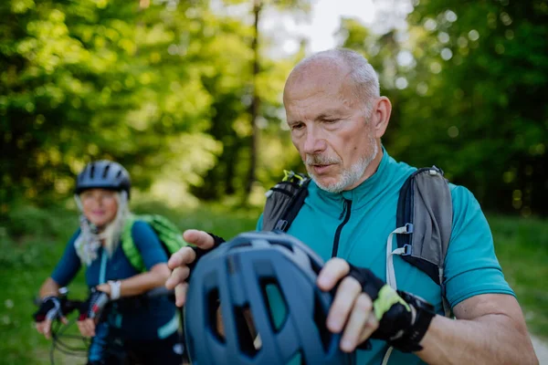 Aktywna Para Seniorów Jeżdżąca Rowerach Letnim Parku Mężczyzna Zakłada Kask — Zdjęcie stockowe