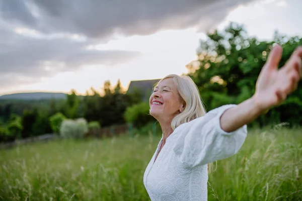 Een Oudere Vrouw Met Uitgestrekte Armen Gezicht Naar Boven Het — Stockfoto