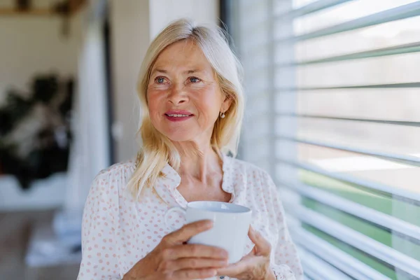 Attractive Senior Woman Drinking Tea Standing Window Home — стоковое фото