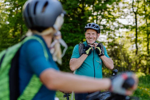 Aktywna Para Seniorów Jeżdżąca Rowerach Letnim Parku Mężczyzna Zakłada Kask — Zdjęcie stockowe