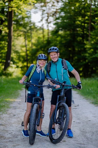 Retrato Casal Sênior Ativo Andando Bicicleta Parque Verão Caminho Olhando — Fotografia de Stock