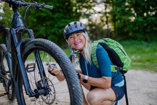 Aktive Seniorin Repariert Fahrrad Und Pumpt Sommer Reifen Der Natur — Stockfoto