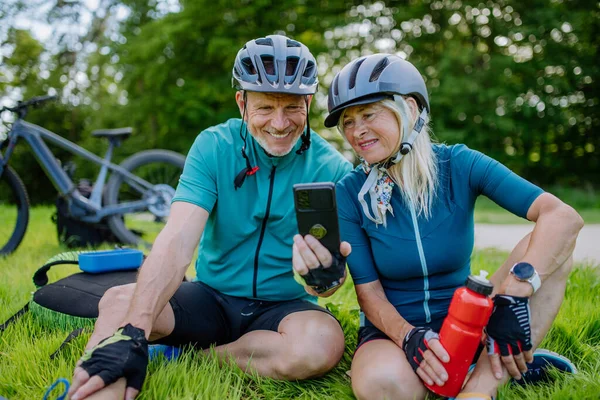 Active Senior Couple Resting Bicycle Ride Summer Park Sitting Grass — Stock Photo, Image