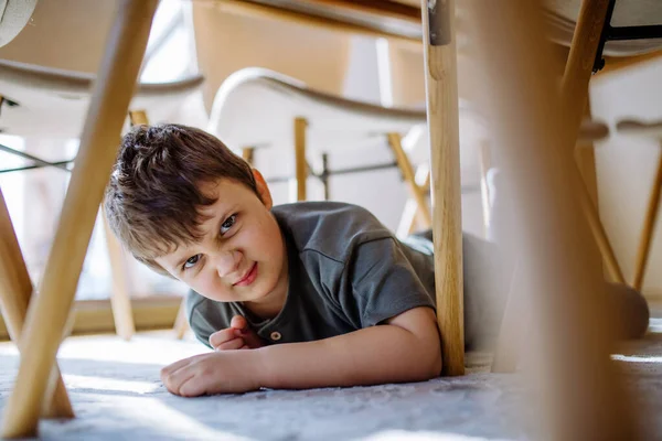 Ein Kleiner Junge Versteckt Sich Hause Unter Dem Stuhl Und — Stockfoto