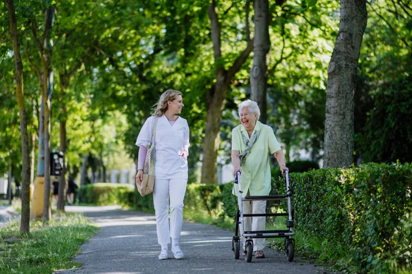 Caregiver Con Donna Anziana Piedi Con Walker Nel Parco Con — Foto Stock