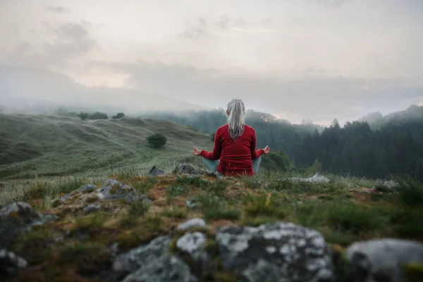 Kıdemli Bir Kadının Sabahın Erken Saatlerinde Arka Planda Sis Dağlarla — Stok fotoğraf