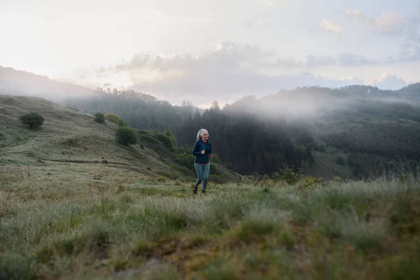 Äldre Kvinna Joggar Naturen Tidig Morgon Med Dimma Och Berg — Stockfoto