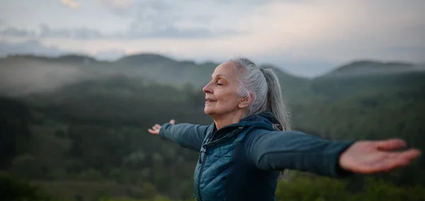 Starsza Kobieta Ćwiczy Oddychanie Naturze Wczesnym Rankiem Mgłą Górami Tle — Zdjęcie stockowe