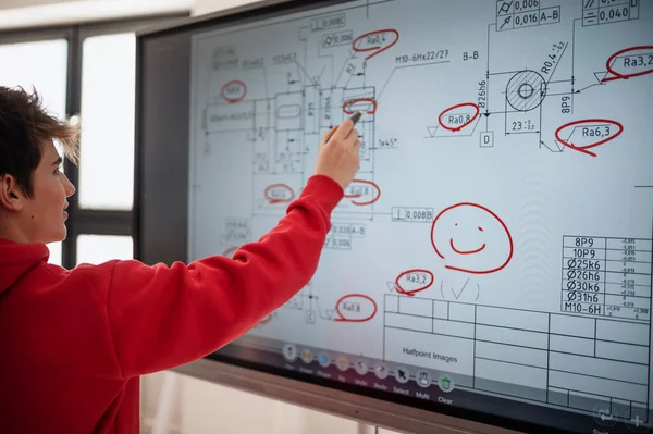 A college student explaining some ideas on a touch TV in classroom.