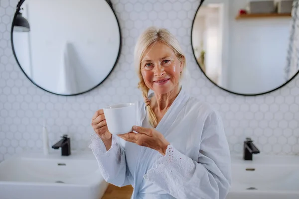 Beautiful Senior Woman Bathrobe Drinking Tea Bathroom Relax Wellness Concept — Stok fotoğraf