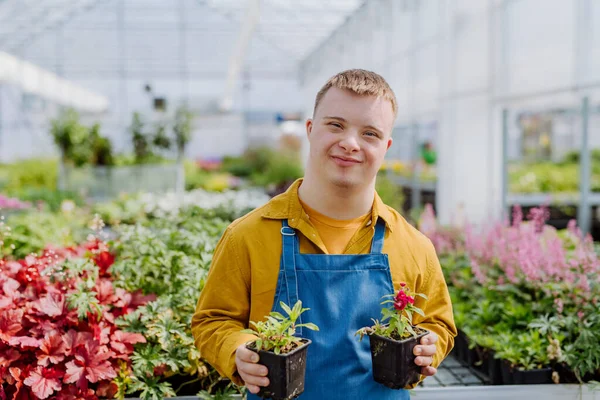 Šťastný Mladý Zaměstnanec Downovým Syndromem Pracující Zahradním Centru Pečující Květiny — Stock fotografie