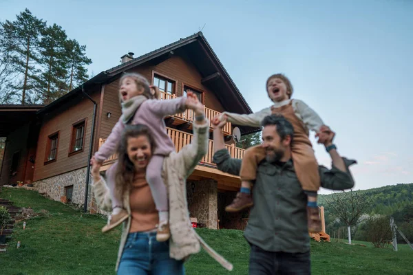 Pais Felizes Com Crianças Pequenas Piggybacks Correndo Divertindo Juntos Jardim — Fotografia de Stock