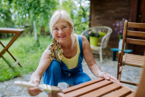 Starsza Kobieta Sprząta Meble Ogrodowe Przygotowuje Ogród Lato — Zdjęcie stockowe