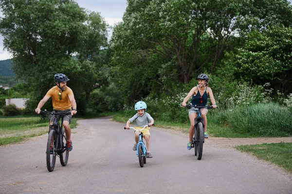 村里有一个年轻的家庭 带着小孩骑自行车在路上 — 图库照片