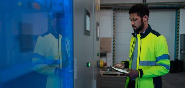 Metal makine endüstrisinde çalışan genç bir sanayi işçisi.