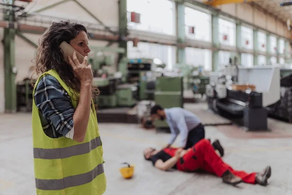 Woman Calling Ambulance Her Colleague Accident Factory First Aid Support — Stockfoto