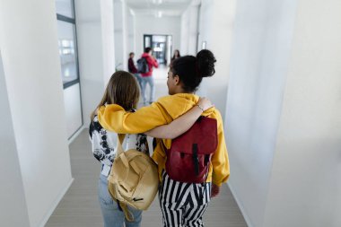 Okul koridorunda yürüyen lise öğrencilerinin okul konseptine geri dönüşleri..