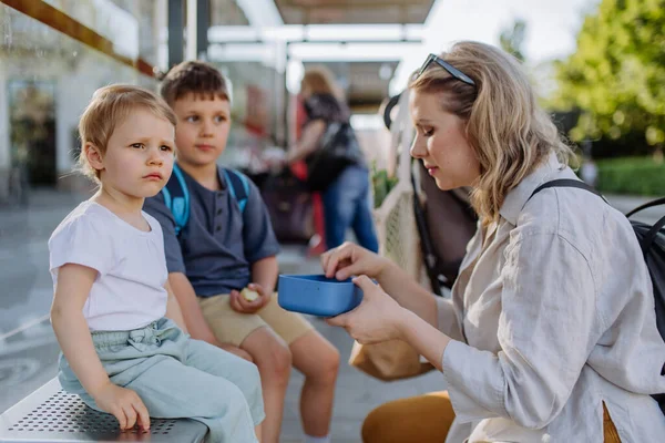 Mladá Matka Malými Dětmi Čeká Autobusové Zastávce Městě Ovocnou Svačinu — Stock fotografie