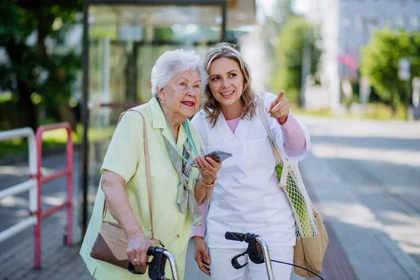 Caregiver Senior Woman Walk Park Shopping Bag Helping Using Smartphone — Foto de Stock