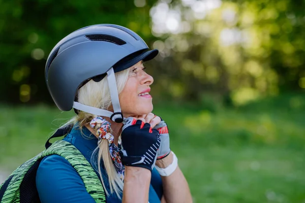 Active Senior Couple Riding Bicycles Summer Park Woman Putting Helmet — Stock Photo, Image