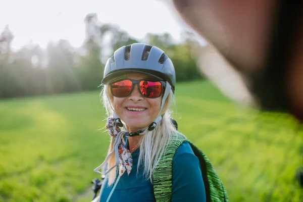 夏の公園 健康的なライフスタイルのコンセプトで道路上の電動自転車に乗るアクティブなシニアカップル — ストック写真