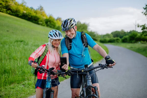 Active Senior Couple Resting Bicycle Ride Summer Park Using Smartphone — Stock Photo, Image