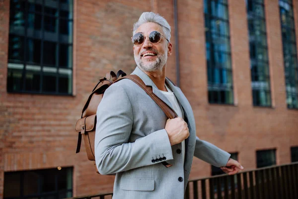 仕事の途中で夏にはカジュアルな服を着たビジネスマン 通りを歩くバックパックを身に着けている自信のある男 — ストック写真