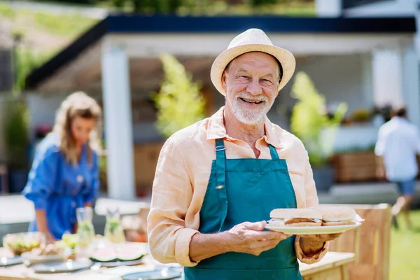 Happy Senior Man Serving Burgers Multi Generation Garden Party Summer — 스톡 사진