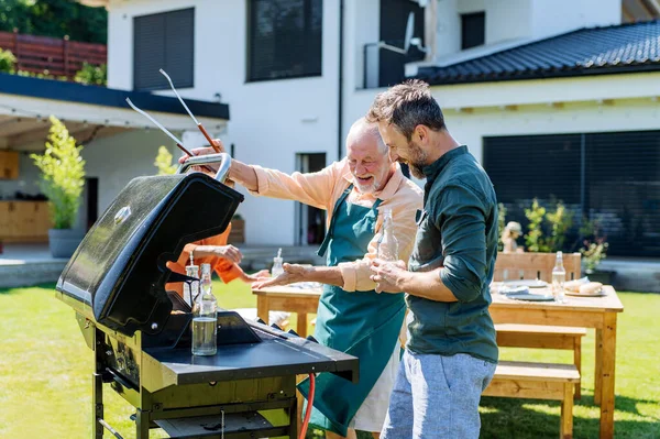 Senior Father Adult Son Grilling Backyard Summer Family Garden Party — Fotografia de Stock