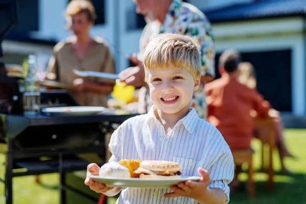 Happy Little Boy Serving Burgers Multi Generation Garden Party Summer —  Fotos de Stock