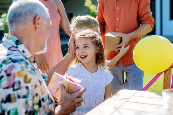 Uma Menina Pequena Feliz Que Presente Aniversário Seu Avô Sênior — Fotografia de Stock