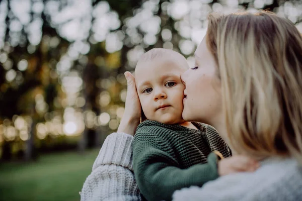 Mother Holding Kissing Her Little Baby Son Wearing Knitted Sweater — 스톡 사진