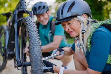 Bisiklet tamir eden, yazın lastiklerini şişiren aktif bir çift..