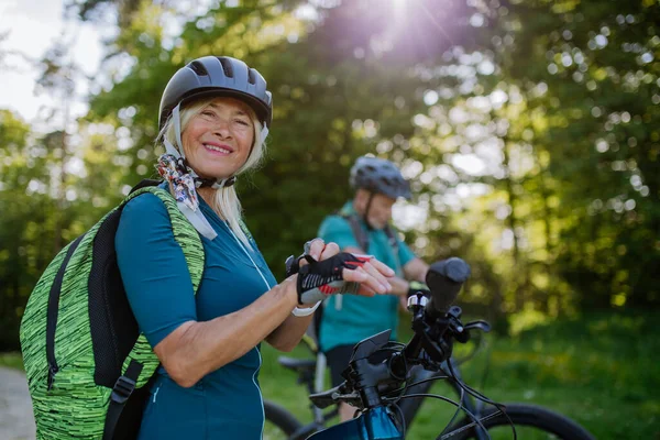 Happy Senior Woman Biker Putting Bicycle Gloves — Zdjęcie stockowe