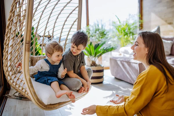 Young Cheerful Mother Playing Her Little Children Having Fun Swinging — Stockfoto